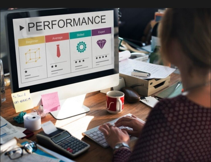 Woman typing on a desktop computer showing performance analytics
